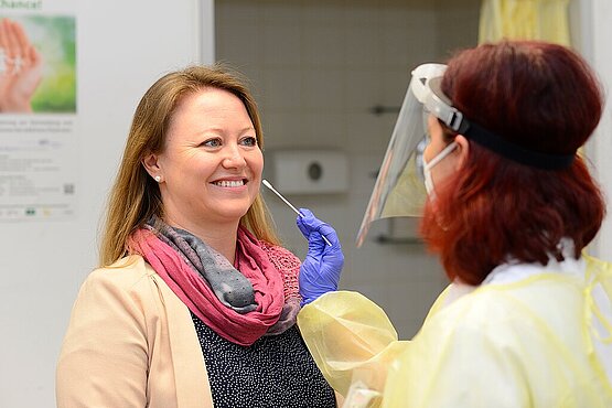 Eine Frau mit einem Gesichtsschutz nimmt den Abstrich einer Patientin. Foto: Klinikum Heidenheim
