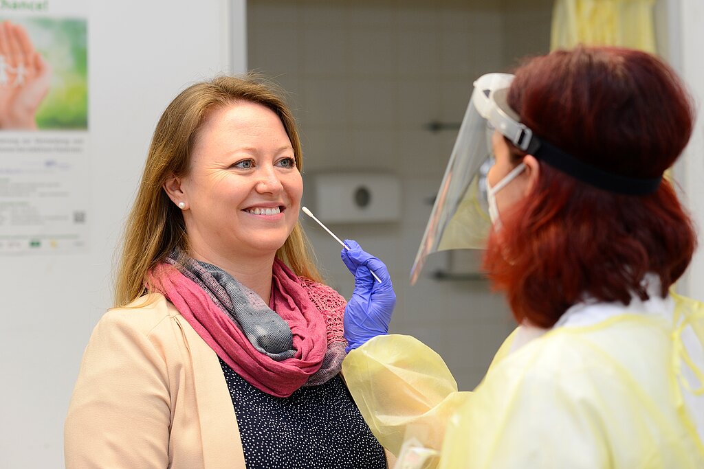 Eine Frau mit einem Gesichtsschutz nimmt den Abstrich einer Patientin. Foto: Klinikum Heidenheim