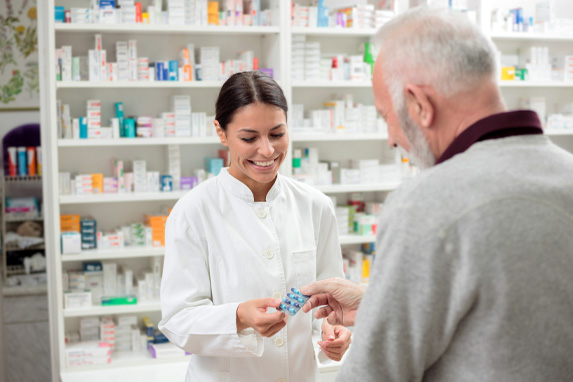 Apothekerin gibt älterem Mann ein Medikament