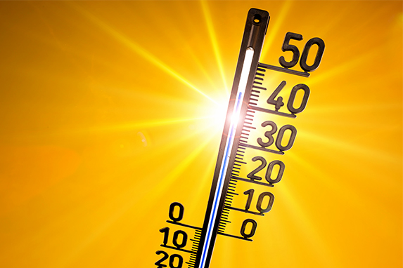 Thermometer mit der Anzeige von 43 Grad und Sonne im Hintergrund