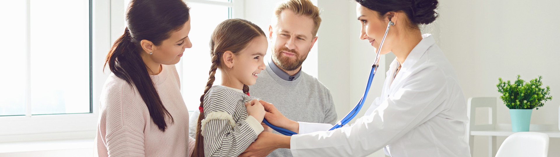 Junge Familie bei Arztbesuch, Ärztin hört die kleine Tochter ab