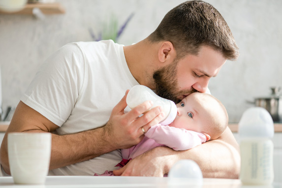 Junger Vater gibt seinem Baby die Flasche