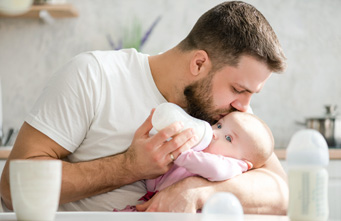 Junger Vater gibt seinem Baby die Flasche